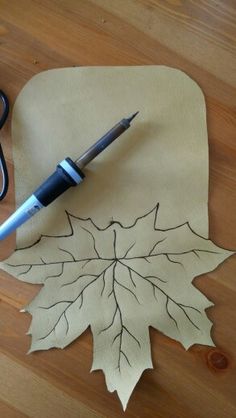 a pen is sitting on top of a piece of paper with a leaf drawn on it