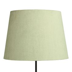 a lamp that is on top of a wooden table with a light green shade over it