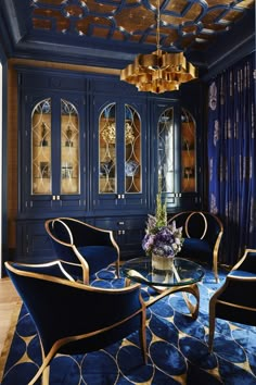 an elegant living room with blue walls and gold trimmings, including two chairs