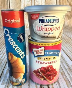 two cans of ice cream sitting next to each other on a wooden table with white boards