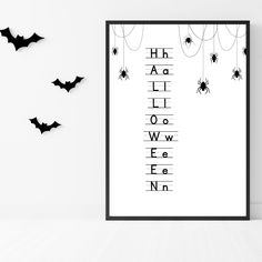 a black and white poster with bats hanging from it's sides in front of a wall