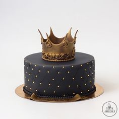 a blue cake with gold decorations and a crown on top