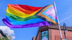 a rainbow colored flag flying in the wind