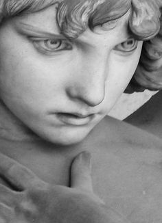 black and white photograph of a statue of a boy with his hands on his chest