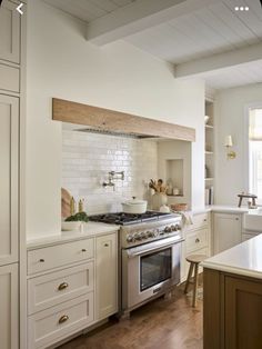 a kitchen with an oven, stove and counter tops in white painted wood paneling