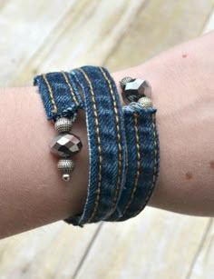 a woman's arm with two bracelets on it, one is blue and the other has silver beads