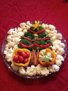 a christmas tree made out of cauliflower and vegetables on a platter with red table cloth