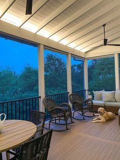 a dog laying on the floor in front of a covered porch with wicker furniture