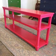 a red table sitting on top of a carpeted floor