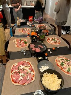 a table topped with pizzas covered in toppings