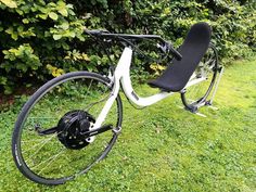 a white bicycle parked on top of a lush green field