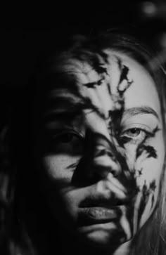 a woman's face is painted with black and white paint, while the image shows an animal pattern