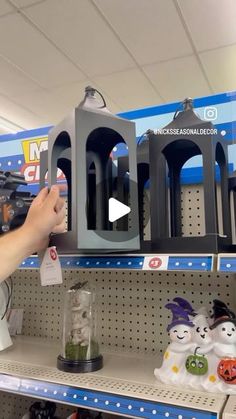 someone is holding up the birdcage in front of their toy store display shelf