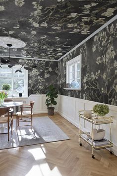 a dining room with floral wallpaper on the ceiling