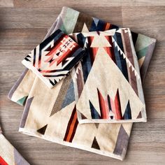 three colorful rugs on top of a wooden floor next to scissors and other items