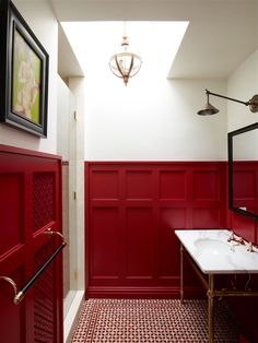 a bathroom with red walls and white fixtures