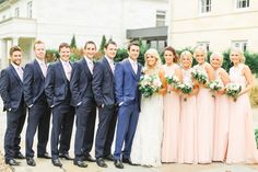 a group of people standing next to each other in front of a white and beige building