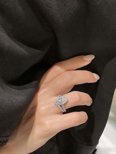 a woman's hand with a diamond ring on it