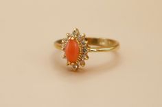 Vintage 18k Gold Electroplated CZ Semi Precious Coral Gemstone Ring Lovely vintage 18k gold plated ring featuring a marquise cut coral gemstone accented by smaller clear cubic zirconia stones. Absolutely perfect condition!  Hallmarked DO - Dolphin Ore Collection - New old stock.  Nickel Free.  Size 8 available.  ------------------------------------------------------- ♡ SHOP POLICIES ♡ ------------------------------------------------------- ♡ All items are vintage and have been pre-loved. Any not Dainty Gold Cluster Ring With Gemstone, Gold Cluster Ring With Stone Setting, Elegant Gold Cluster Ring With Stone Setting, Gold Cluster Ring With Stone Setting For Gift, Gold Cluster Ring With Stone Setting As Gift, Gold Cluster Ring With Stone Setting - Perfect Gift, Coral Rings, Coral Stone Ring, Coral Jewelry Vintage