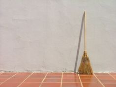 a broom sitting on top of a red tiled floor