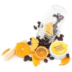 orange slices and raisins are scattered around a glass jar