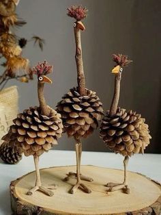 two birds made out of pine cones sitting on top of a tree stump