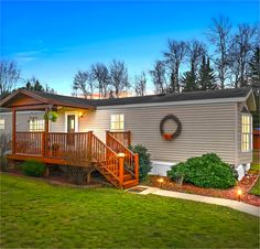 a mobile home with stairs leading up to the front door and steps down to the porch