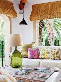 a living room filled with lots of furniture and pillows on top of a wooden table