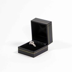 an engagement ring in a black box on a white background