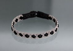 a black and white braided bracelet sitting on top of a table