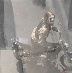 a woman with painted face sitting on a motorcycle