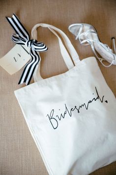 a white bag with the word bridesmaid written on it next to some shoes