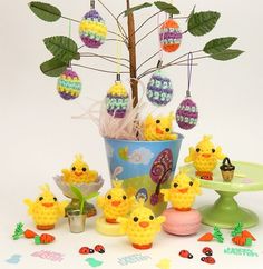 there is a potted plant with crochet easter eggs and chicks in it