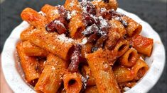 a white bowl filled with pasta covered in powdered sugar