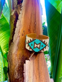 a beaded bracelet sitting on top of a tree branch