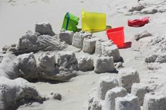 colorful plastic chairs and sandcastles on the beach