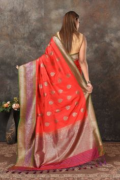 Look royal at weddings and festive occasions in this stunning red Banarasi saree. The saree is crafted with zari buta and green purple zari border. It comes with a matching blouse piece. Disclaimer: The shown stitched blouse on the model is for display purpose only. The saree comes with a matching blouse piece and finished with fall and piko. DISCLAIMER: The actual product may vary slightly from the image. These are custom orders, hence expect slight variation in color and placement of the motif Red Banarasi Saree, Partywear Sarees, Bollywood Sarees, Tussar Silk Sarees, Fashion Journals, Tussar Silk Saree, Banarasi Saree, Indian Saree, Traditional Fabric