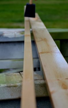 an apple watch sitting on top of a wooden bench next to a green grass field