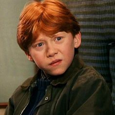 a young boy with red hair sitting down