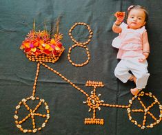 a baby laying on top of a table next to a bike made out of beads