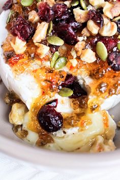 a close up of a plate of food with fruit and nuts on the top of it