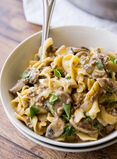 a white bowl filled with pasta and mushrooms