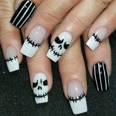 the nails are decorated with black and white stripes, skulls and jack - o'- lanterns