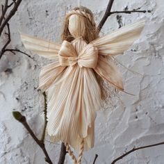 an angel ornament hanging from a tree branch