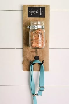 a mason jar hanging on the wall with a blue lanyard strap attached to it