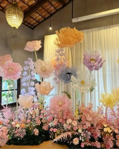 an arrangement of flowers on display in front of a window