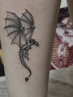 a black and white dragon tattoo on the leg