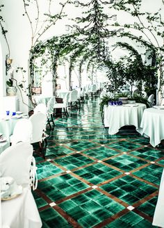 tables and chairs are set up with white linens