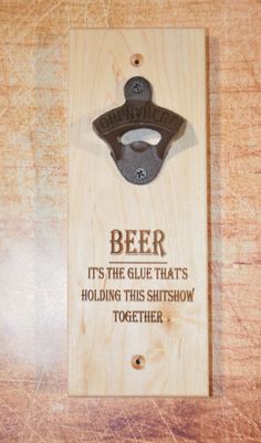 a wooden sign with a bottle opener on it that says beer its the glue that's holding this shitshow together