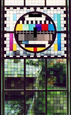 a stained glass window with an image of a building in the center and trees behind it